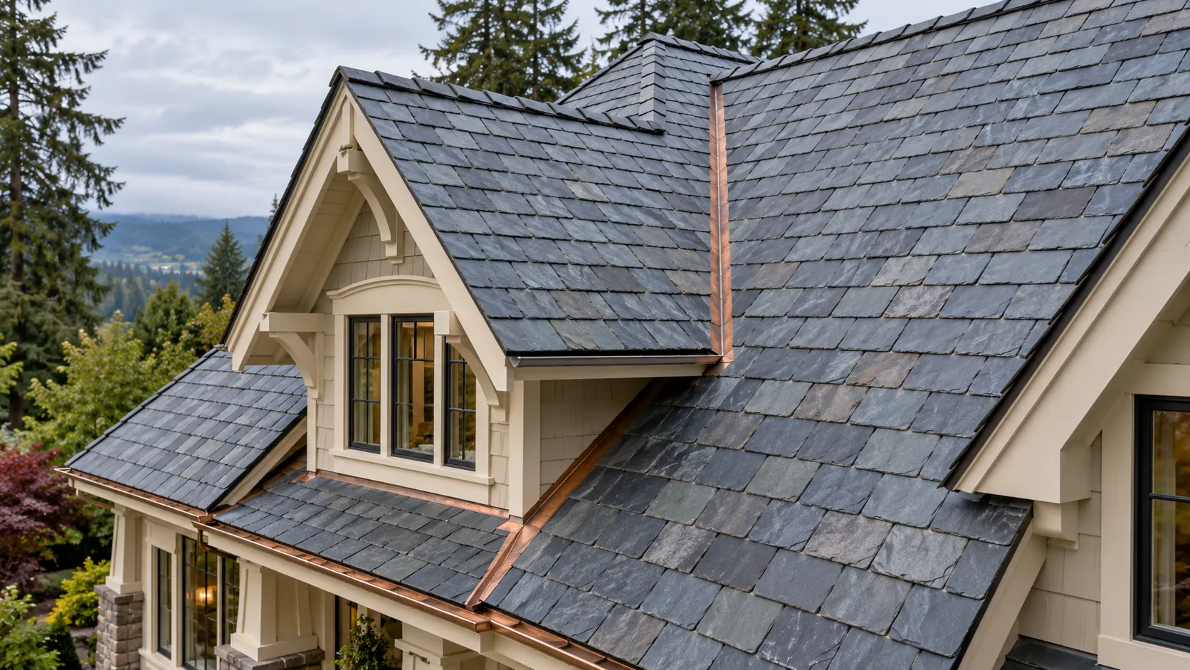 Blue-gray slate tiles with copper valley flashing and a cream-colored dormer on a tree-lined home.